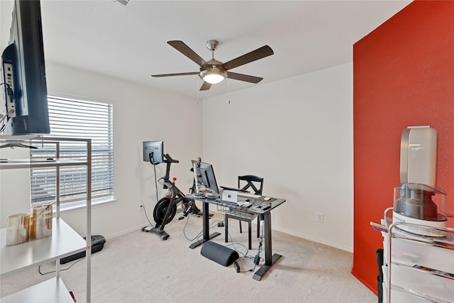 workout area with ceiling fan, baseboards, and light carpet