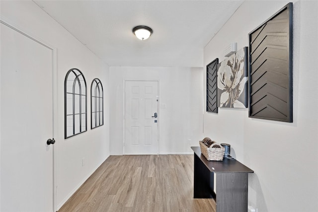 foyer entrance featuring light wood-style floors and baseboards