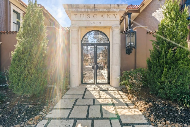 property entrance with a tile roof and stucco siding