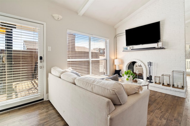 living room featuring dark wood finished floors, lofted ceiling with beams, and a fireplace