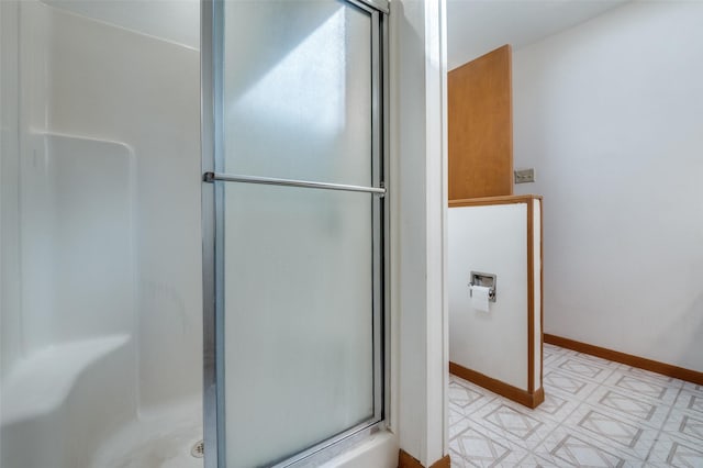 bathroom with tile patterned floors, baseboards, and a stall shower