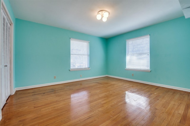 unfurnished bedroom with wood finished floors, a closet, and baseboards