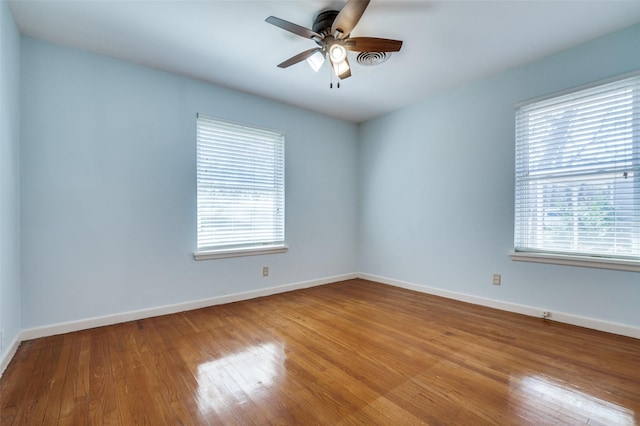 unfurnished room featuring a ceiling fan, plenty of natural light, and wood finished floors