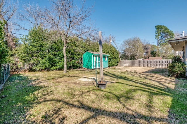 view of yard with an outbuilding, a fenced backyard, and a shed