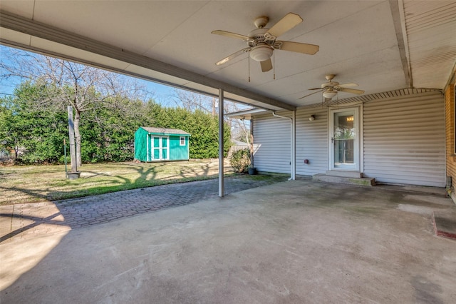 view of patio featuring ceiling fan, an outdoor structure, and a shed