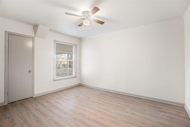 empty room featuring ceiling fan, baseboards, light wood finished floors, and ornamental molding