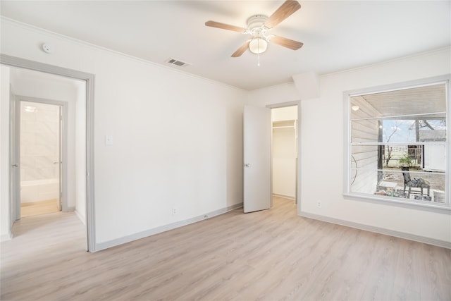 unfurnished room with light wood-type flooring, visible vents, ornamental molding, baseboards, and ceiling fan