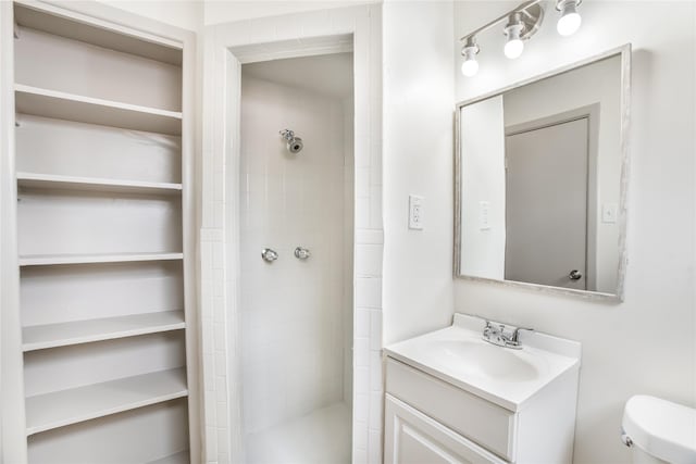 full bathroom with vanity, a shower stall, and toilet