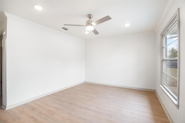 empty room featuring visible vents, crown molding, baseboards, ceiling fan, and light wood-style flooring