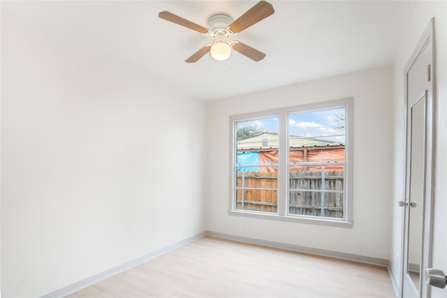 unfurnished room featuring light wood-style flooring, a ceiling fan, and baseboards