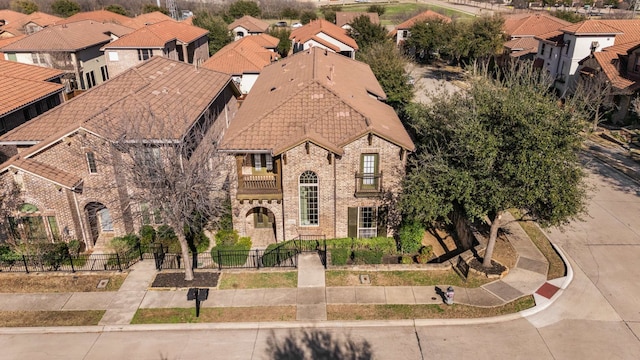 view of front of house with brick siding, fence, and a residential view