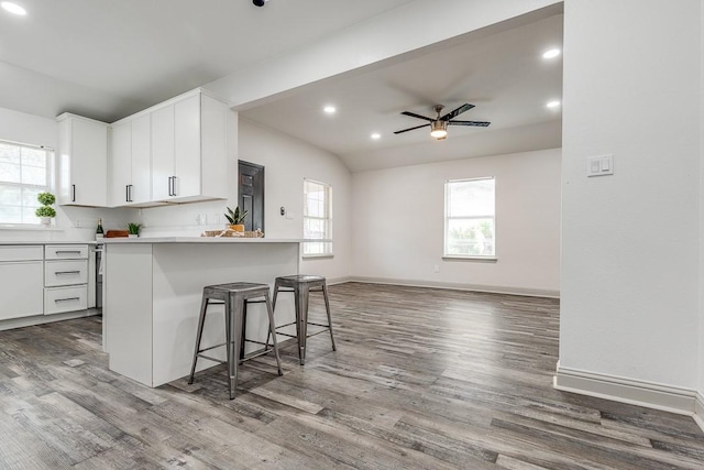 559 Helena St, Dallas, TX 75217 - kitchen featuring a ceiling fan, a kitchen bar, wood finished floors, white cabinetry, and open floor plan