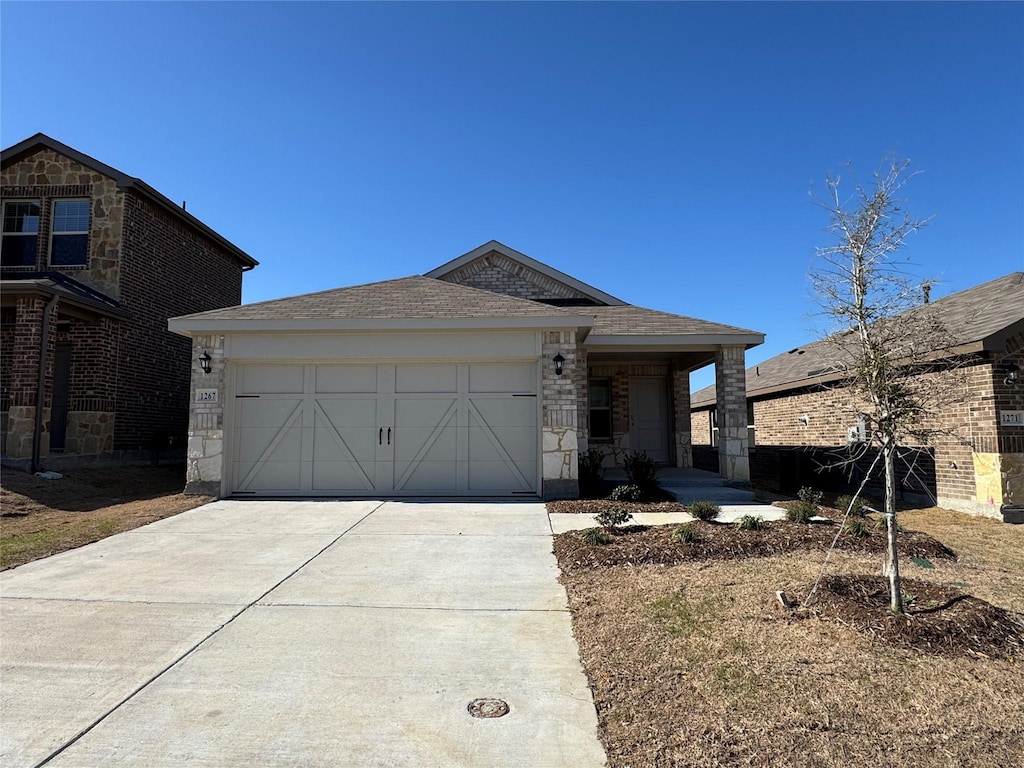 view of front of property featuring brick siding, driveway, a garage, and a shingled roof