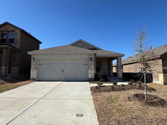 view of front of property featuring brick siding, driveway, a garage, and a shingled roof