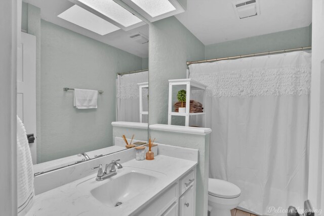 bathroom featuring vanity, visible vents, a skylight, curtained shower, and toilet