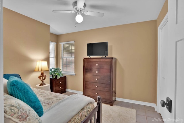 tiled bedroom featuring a ceiling fan and baseboards