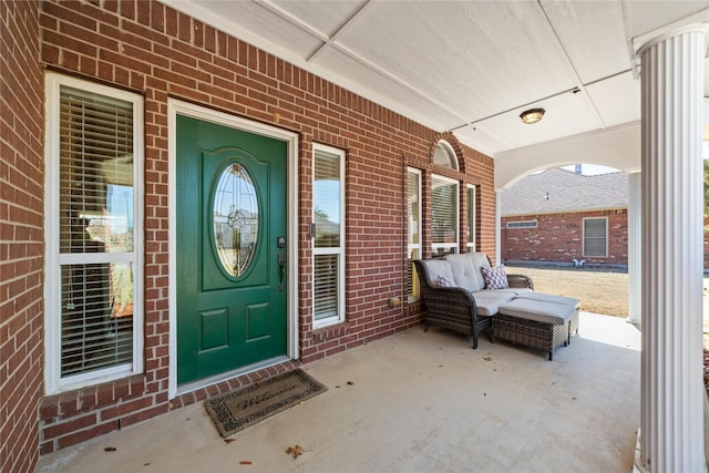 entrance to property with brick siding and a porch