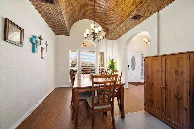 dining area with baseboards, dark wood finished floors, lofted ceiling, arched walkways, and brick ceiling