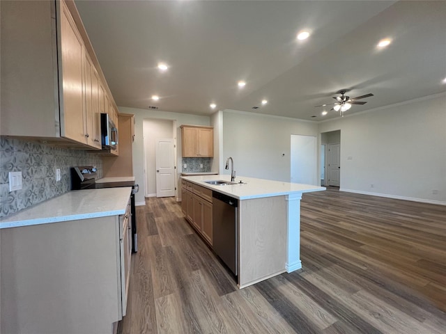 kitchen with a center island with sink, dark wood finished floors, a sink, light countertops, and appliances with stainless steel finishes