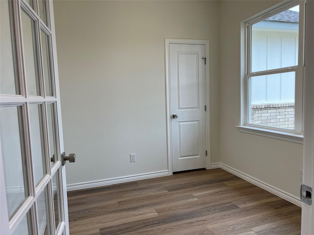 empty room featuring baseboards and dark wood-style flooring