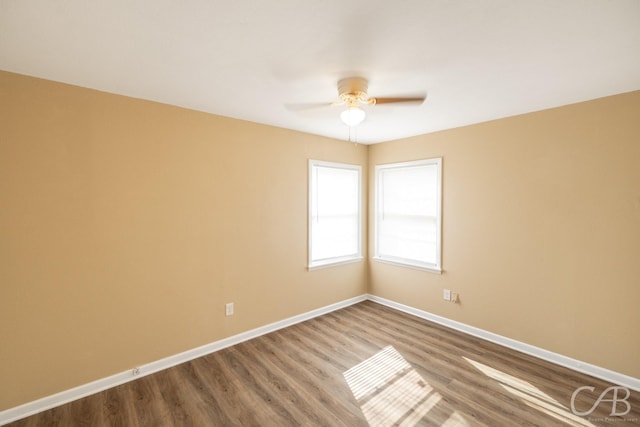 unfurnished room featuring baseboards, wood finished floors, and a ceiling fan