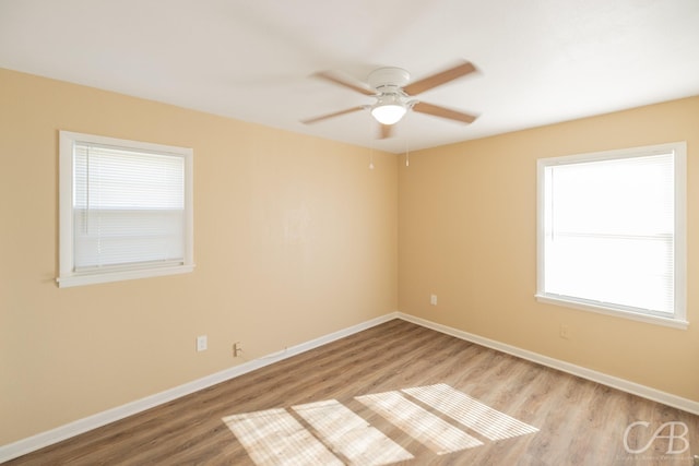 unfurnished room with a ceiling fan, baseboards, and wood finished floors