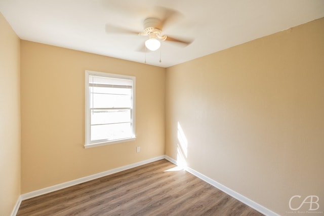 empty room with a ceiling fan, wood finished floors, and baseboards