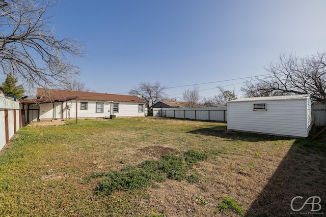 view of yard featuring an outdoor structure, a fenced backyard, and a shed