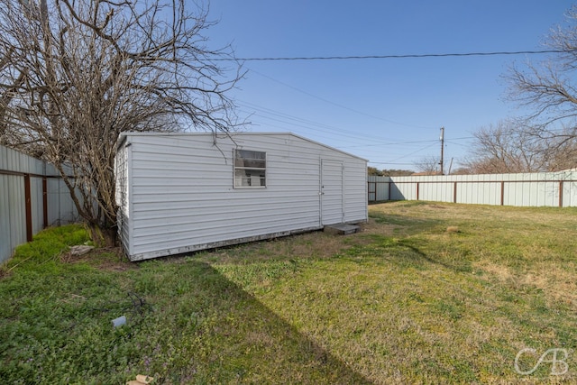 view of yard with an outdoor structure, a storage unit, and a fenced backyard