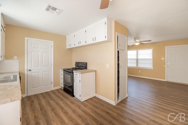 kitchen featuring visible vents, dark wood-type flooring, a sink, black / electric stove, and white cabinets