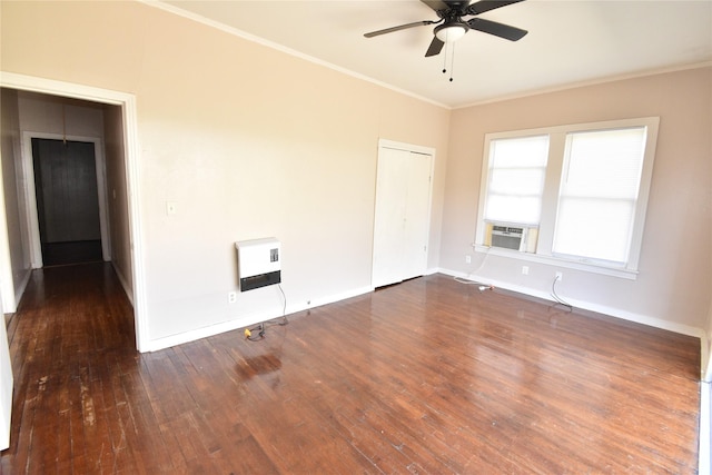 spare room featuring heating unit, dark wood-style floors, baseboards, and ornamental molding