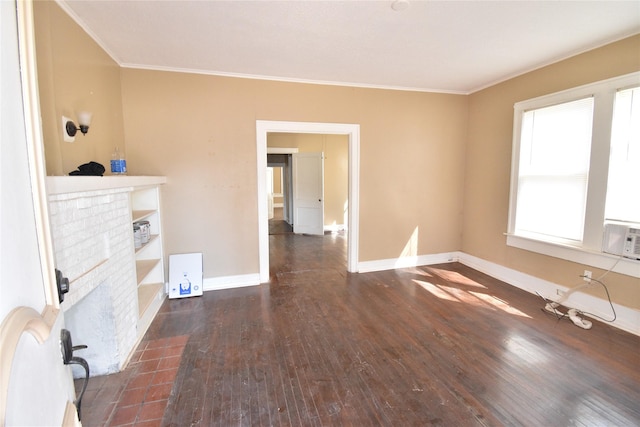 unfurnished living room featuring baseboards, a fireplace, wood finished floors, and crown molding