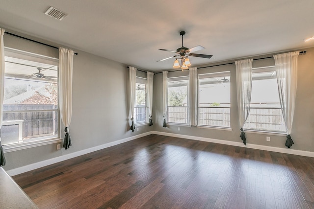 spare room with visible vents, baseboards, dark wood-type flooring, and ceiling fan