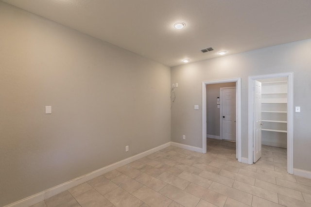 spare room featuring baseboards and light tile patterned floors