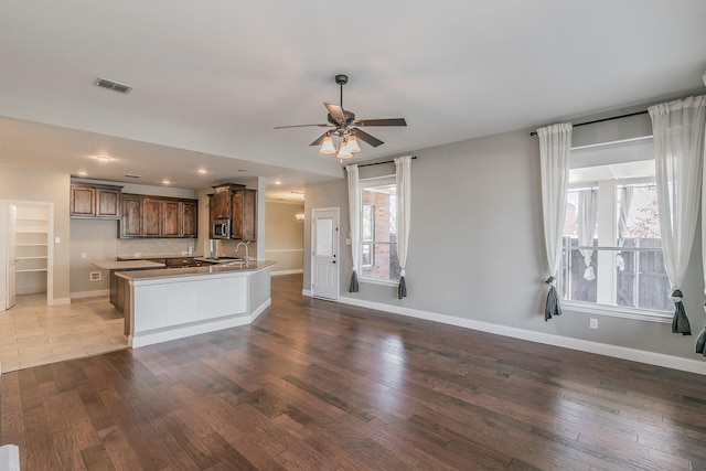 kitchen with stainless steel microwave, wood finished floors, baseboards, a ceiling fan, and recessed lighting