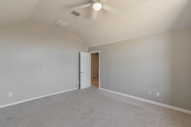 spare room featuring visible vents, baseboards, lofted ceiling, ceiling fan, and light carpet