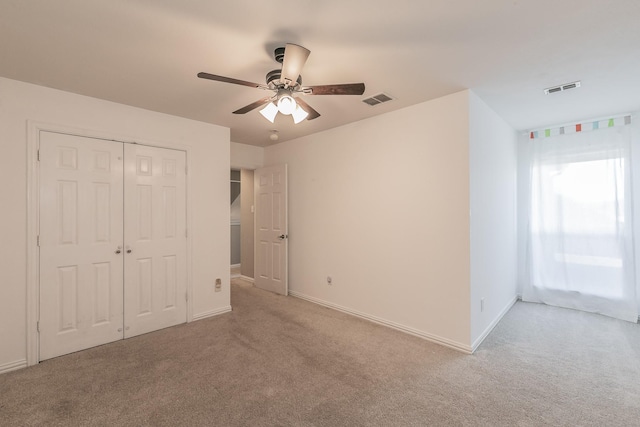 unfurnished bedroom featuring carpet floors, baseboards, a closet, and ceiling fan