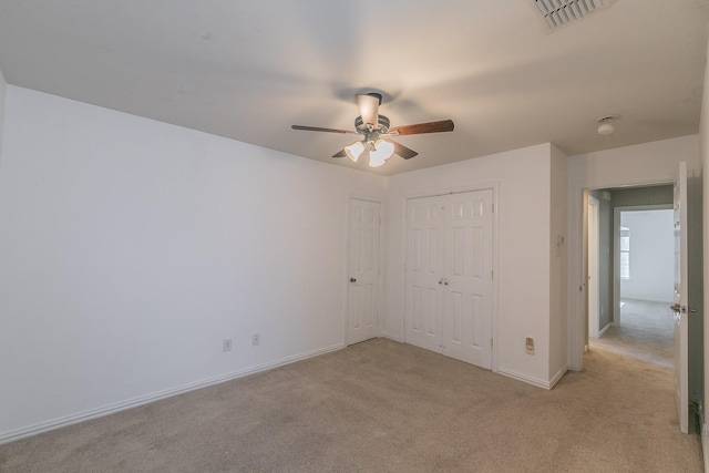 unfurnished bedroom featuring light carpet, a closet, baseboards, and ceiling fan