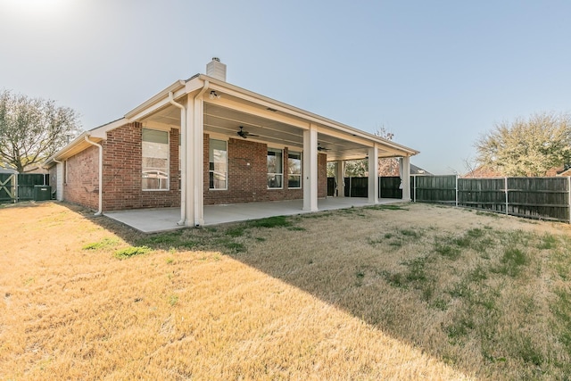 back of house featuring a patio, a ceiling fan, a fenced backyard, a chimney, and brick siding