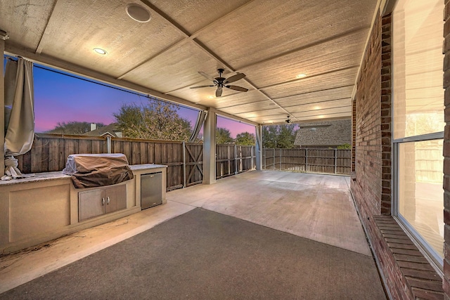 view of patio featuring an outdoor kitchen, fence, ceiling fan, and area for grilling