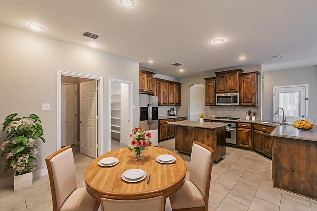 713 Cross Meadow Blvd, Mansfield, TX 76063 - kitchen with stainless steel appliances, arched walkways, a sink, light tile patterned floors, and recessed lighting