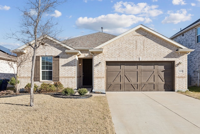 view of front facade featuring brick siding, driveway, a shingled roof, and a garage