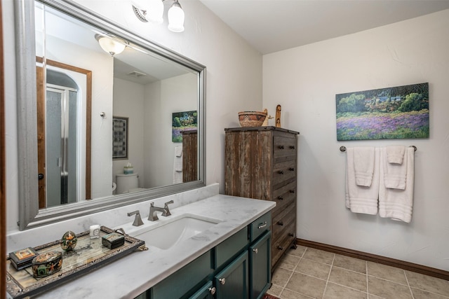 full bath featuring tile patterned flooring, a shower stall, baseboards, toilet, and vanity