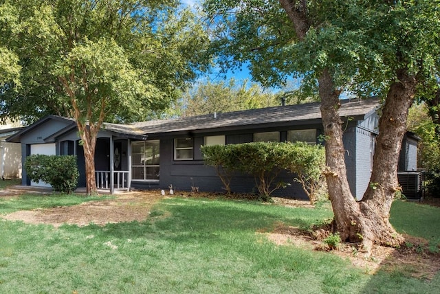 ranch-style home featuring brick siding, cooling unit, a front yard, and a sunroom