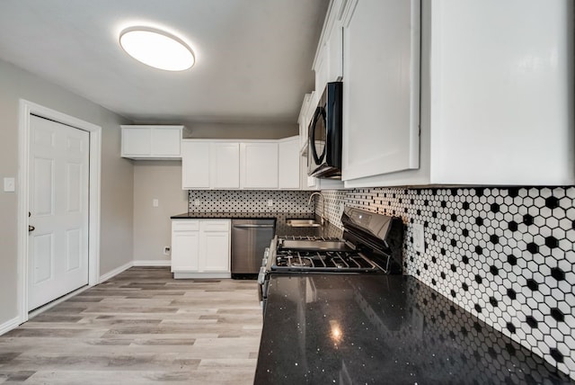 kitchen with light wood-style flooring, a sink, appliances with stainless steel finishes, white cabinets, and decorative backsplash