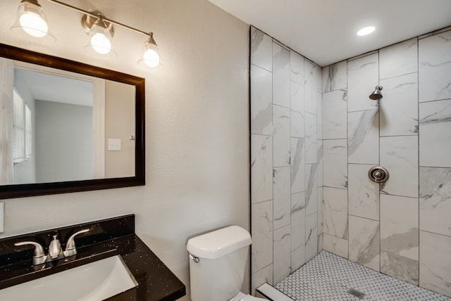 full bathroom featuring vanity, toilet, and a tile shower