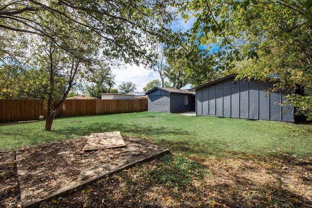 view of yard featuring an outbuilding, a shed, and fence