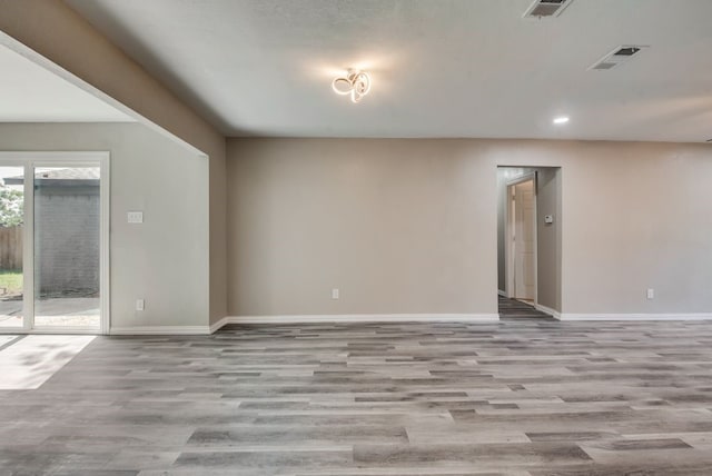 empty room with visible vents, baseboards, and wood finished floors