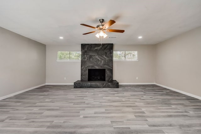 unfurnished living room featuring plenty of natural light, visible vents, a fireplace, and baseboards