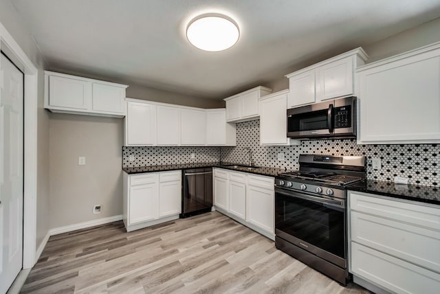 kitchen featuring dark countertops, light wood-style flooring, stainless steel appliances, and tasteful backsplash